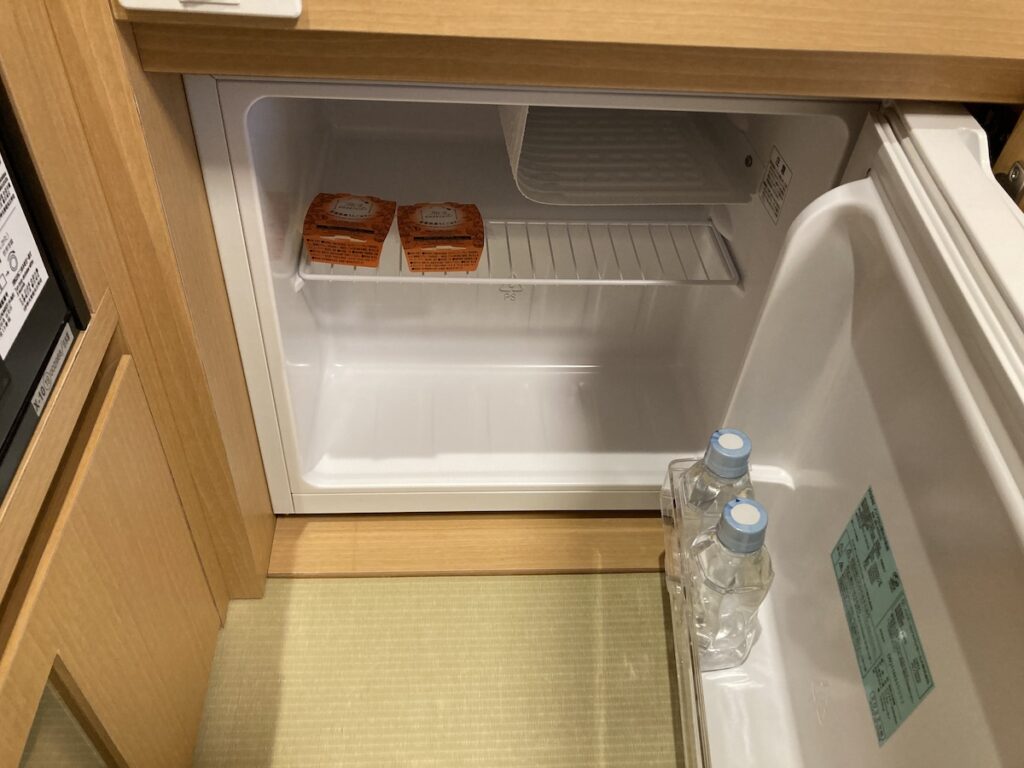 客室の冷蔵庫にミネラルウォーターとウェルカムデザートが入っている